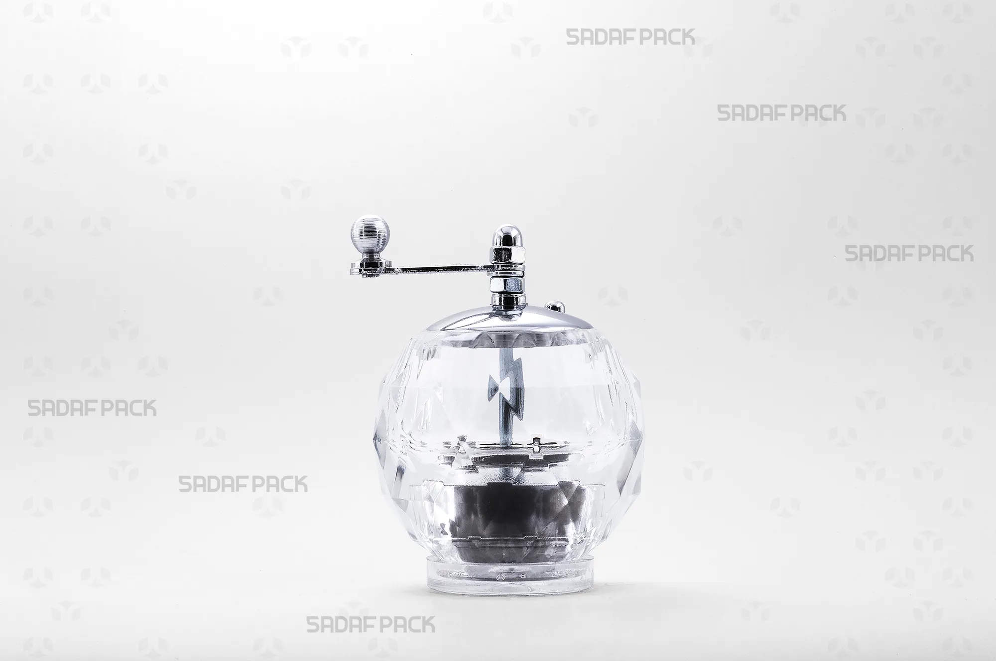 sadafpack-zaferan-sab-almas.webp نمای روبروی زعفران ساب کریستالی مدل الماس صدف پک، با بدنه شفاف برای مشاهده محتویات، درپوش و دسته فلزی با آبکاری کروم و مکانیزم سایش چرخشی برای پودر کردن یکنواخت رشتههای زعفران