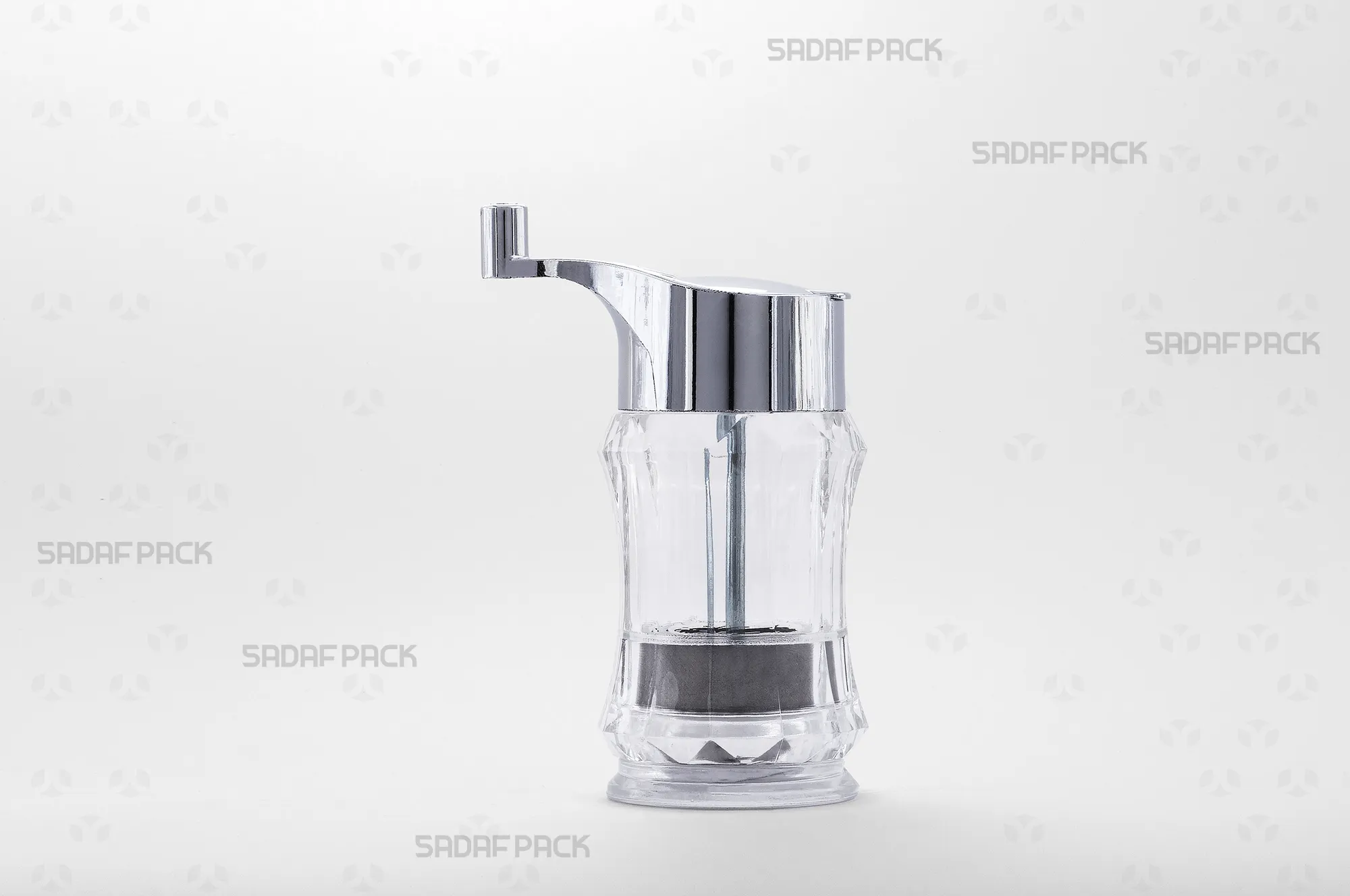 sadafpack-zaferan-sab-sadaf.webp نمای روبروی زعفران ساب کریستالی مدل صدف صدف پک، با بدنه شفاف برای مشاهده محتویات، کلاهک و دسته فلزی با روکش کروم، و مکانیزم چرخشی برای سابیدن یکنواخت زعفران